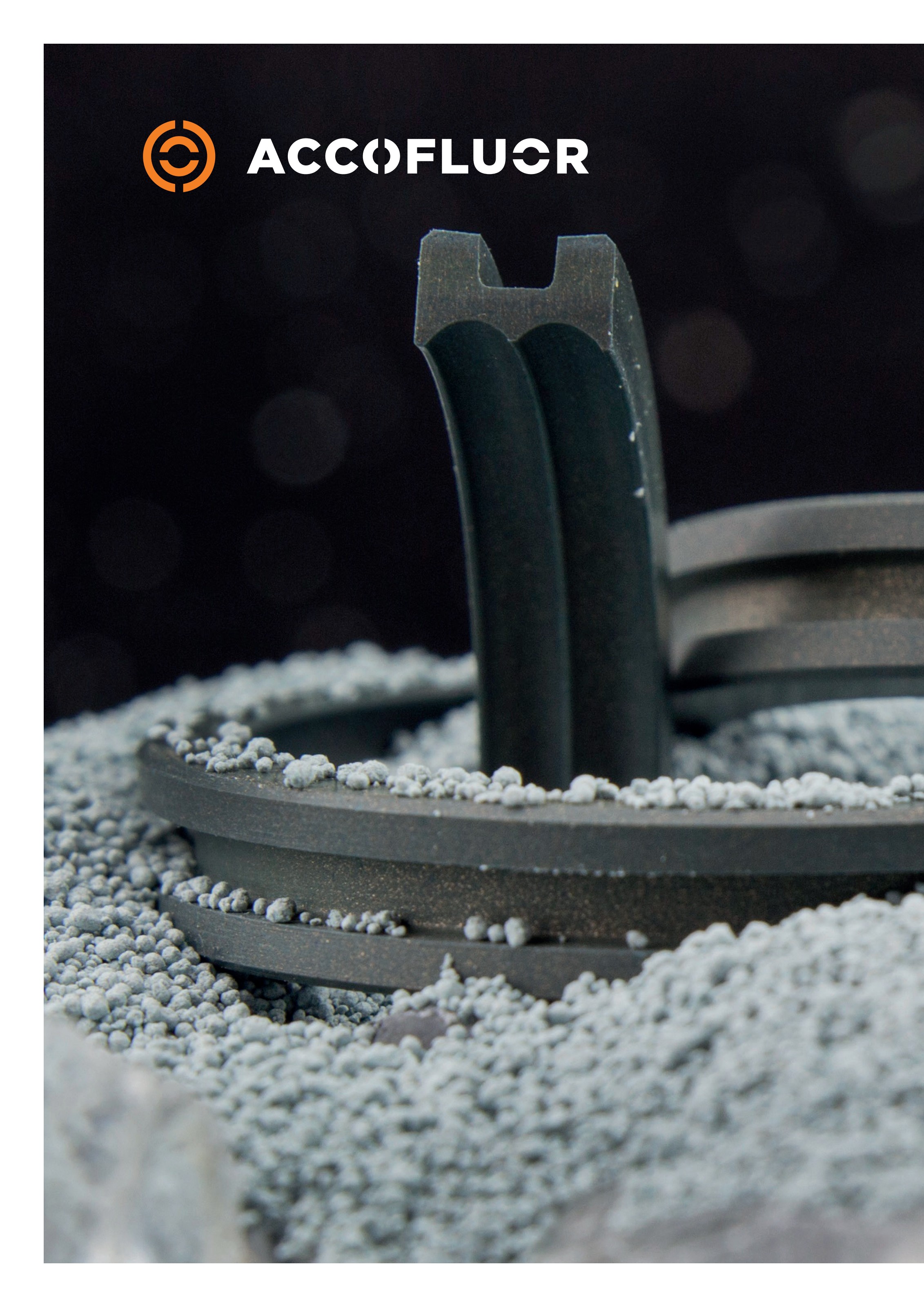 Black H-shaped PTFE seal ring on a bed of grey PTFE powder